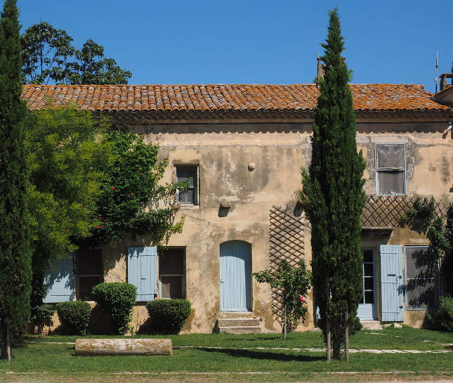Frans huis met strak blauwe hemel en gazon