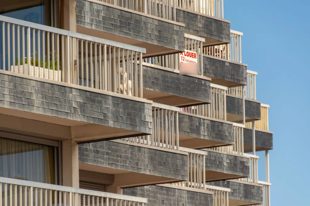 Balkons van een Frans appartementencomplex met een bord À louer, T2 saisonnier